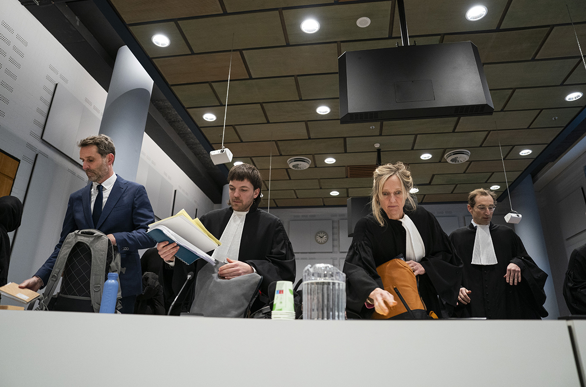 Oxfam-directeur Michiel Servaes in de rechtszaal samen met advocaten