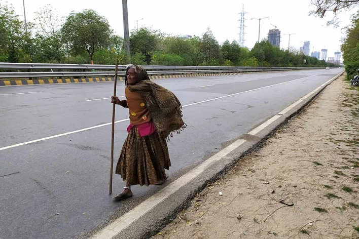 Een vrouw loopt over de lege straat naar haar dorp